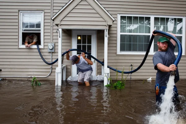 Golden Touch Restoration Specialist LLC pumping floodwater out of a New York house during emergency water damage cleanup.